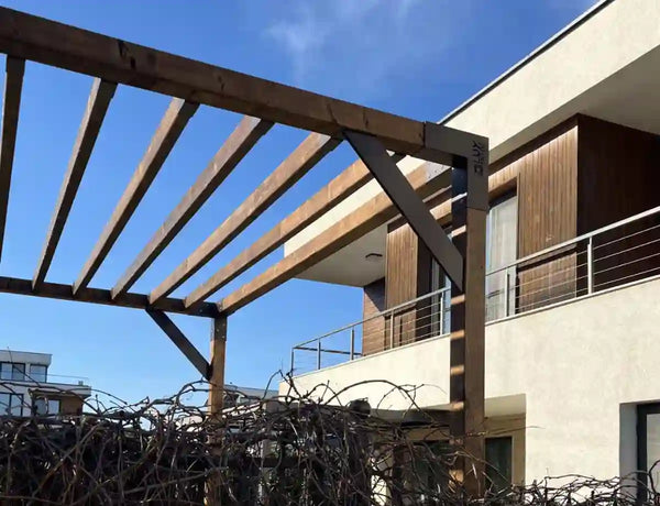 Wooden pergola structure on a rooftop with modern building in the background