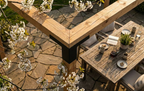 Tavolo da esterno in legno con fiori e un patio in pietra