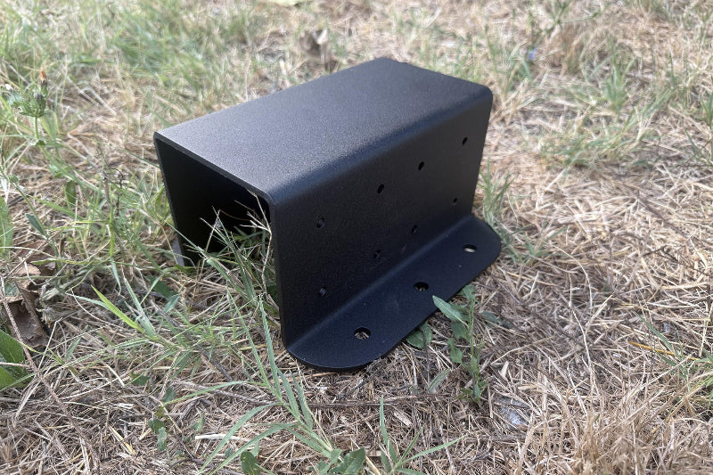 Black metal bracket on a grassy ground